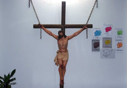 Altar con la imagen de Cristo crucificado y los dibujos de los feligreses de la parroquia que ven a su iglesia de diferentes colores, incluido el rojo