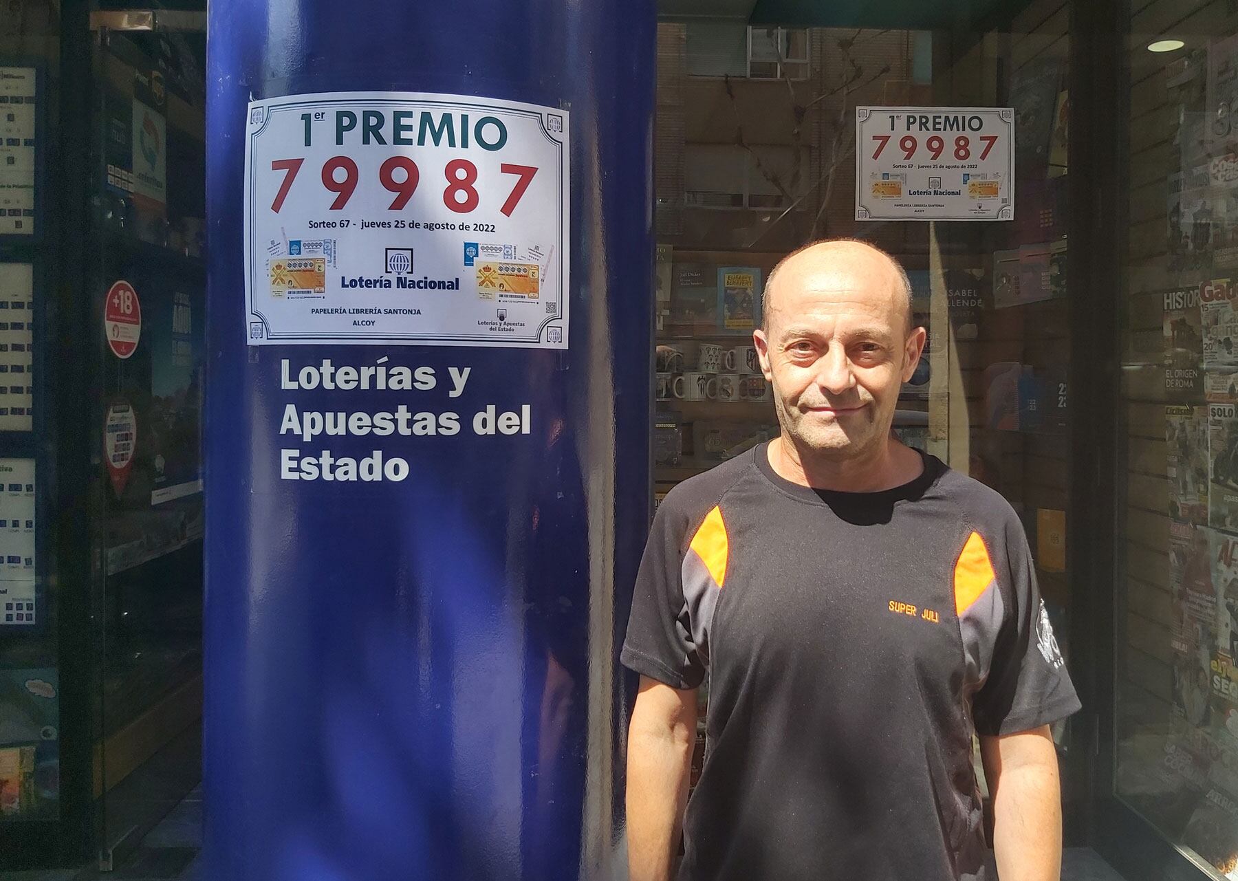 Juli Ferrer, en el exterior de la Papelería Santonja, junto al indicativo del premio entregado