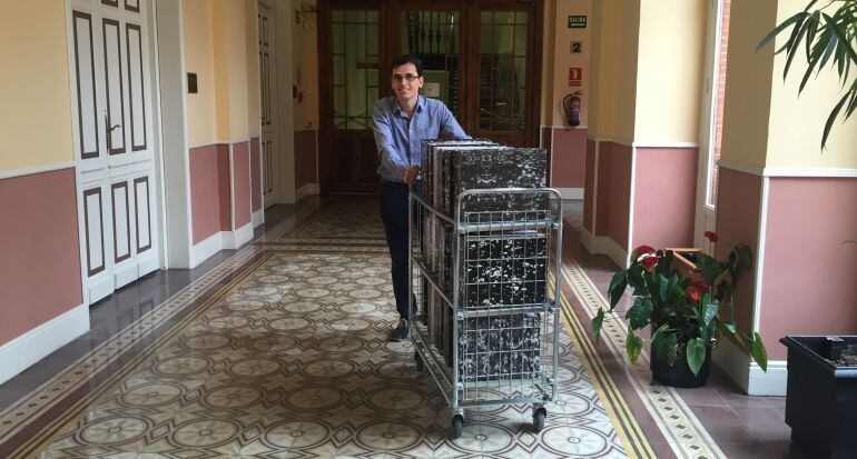 El portavoz del PSOE, Pedro Herrero, arrastra un carro cargado con carpetas por los pasillos del Ayuntamiento de Valladolid