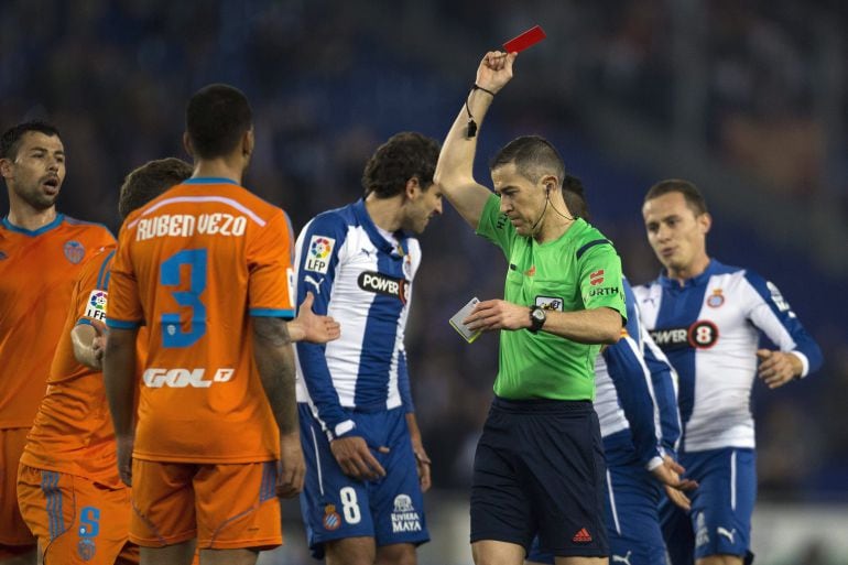 GRA279. CORNELLÁ. 13/01/2015.- El árbitro Iglesias Villanueva muestra tarjeta roja al alemán Shkodran Mustafi, defensa del Valencia CF, durante el partido de vuelta de los octavos de final de la Copa del Rey que RCD Espanyol y Valencia CF disputan esta noche en el estadio Power 8, en Cornellá-El Prat. EFE/Alejandro García