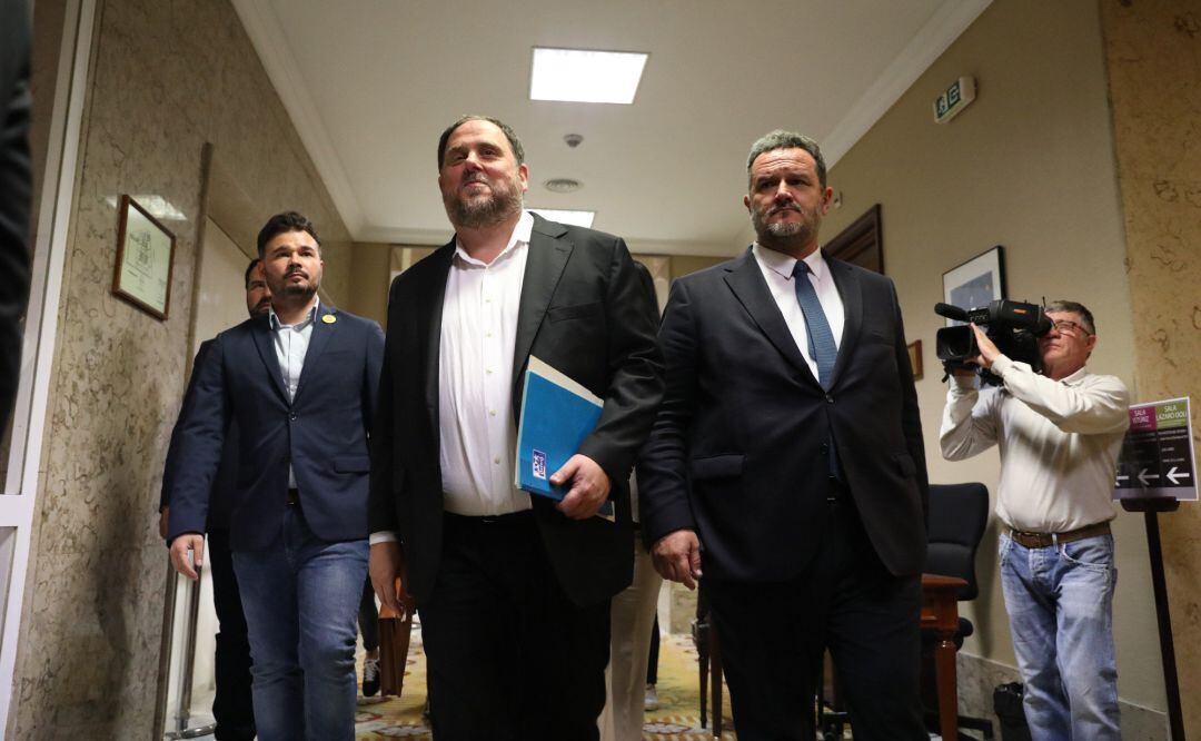 El exvicepresidente de la Generalitat, Oriol Junqueras, sale del Congreso de los Diputados, donde ha iniciado los trámites pertinentes para recoger su acta de diputado. A su derecha, le acompaña Gabriel Rufián (ERC).