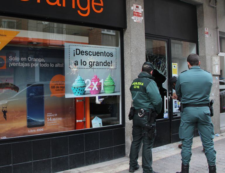 Agentes de la Guardia Civil observan los daños producidos por el intento de robo en una tienda de móviles en Cuéllar