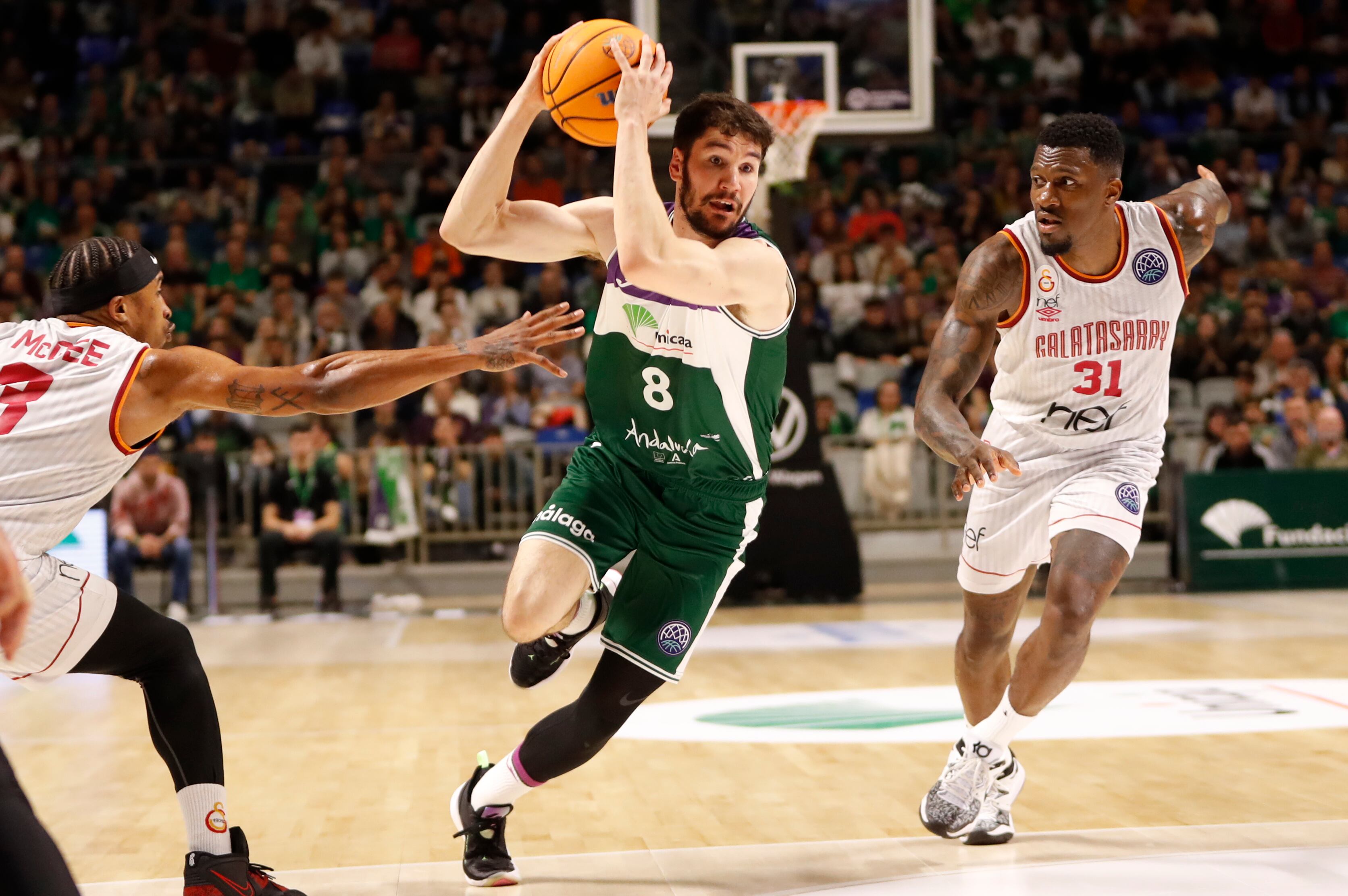 MÁLAGA, 07/03/2023.- El escolta del Unicaja Darío Brizuela (c) supera a Tyrus McGee (i) y Dylan Ennis, ambos del Galatasaray durante el partido de Liga de Campeones de baloncesto que se disputa este martes en el Palacio de los Deportes José María Martín Carpena de Málaga. EFE/ Jorge Zapata