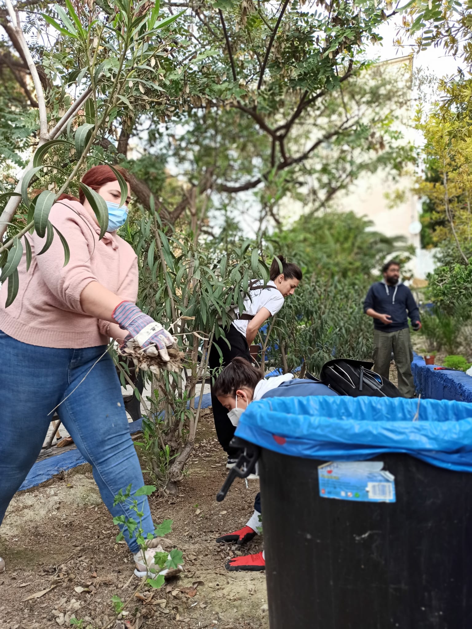 Vecinos limpiando una zona verde de Colonia Requena por la falta de actuación del Ayuntamiento