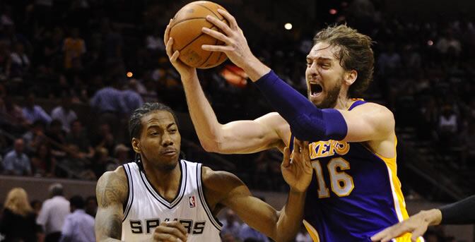 El jugador español de Los Ángeles Lakers, Pau Gasol, avanza hacia la cesta junto a Kawhi Leonard de San Antonio Spurs