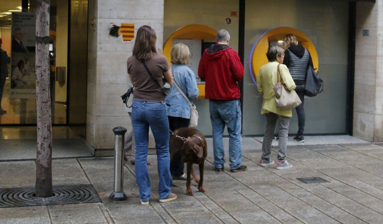 Cues als caixers de CaixaBank per a la retirada d'efectiu, al centre de Mataró, el 20 d'octubre de 2017. (horitzontal)