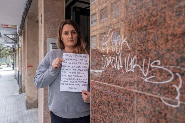 Mirian Armero, cajera de un supermercado de Cartagena, muestra en el portal del edificio donde vive, la carta que un vecino metida por debajo de su puerta y que encontró su hijo de 10 años, en la que le recomiendan que se busque otra vivienda mientras dura la pandemia del COVID 19