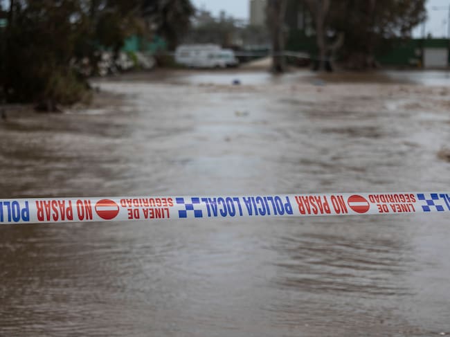 MOGÁN (CANARIAS), 21/03/2026.- Corte de carretera en la desembocadura del barranco de Arguinegín a la costa de Mogán. . El Gobierno de Canarias ha activado este sábado la alerta por riesgo de inundaciones pluviales y por desprendimientos en las islas occidentales y en Gran Canaria, con motivo del paso del frente de la borrasca Therese, que azota el archipiélago desde el pasado miércoles. EFE/ Quique Curbelo