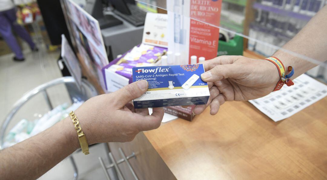 Un farmacéutico enseña un test de antígenos de detección del COVID-19.