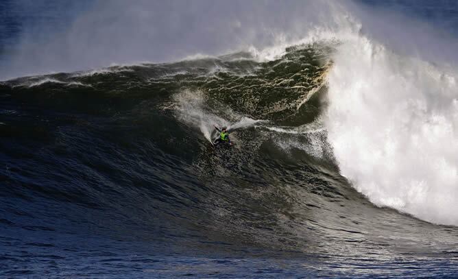 El surfista vasco Axi Muniain surfea sobre una gran ola hoy en una cala del monte Igueldo de San Sebastián durante el temporal que azota el mar Cantábrico