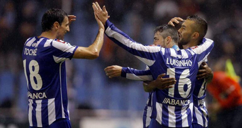 El delantero argentino del Deportivo Luis Carlos Fariña (d) recibe la felicitación de sus compañeros José Verdú &quot;Toché&quot; (i), y Luis Carlos Correia &quot;Luisinho&quot; (2ºd), tras marcar gol ante el Elche, durante el partido de la decimoquinta jornada de la Liga de