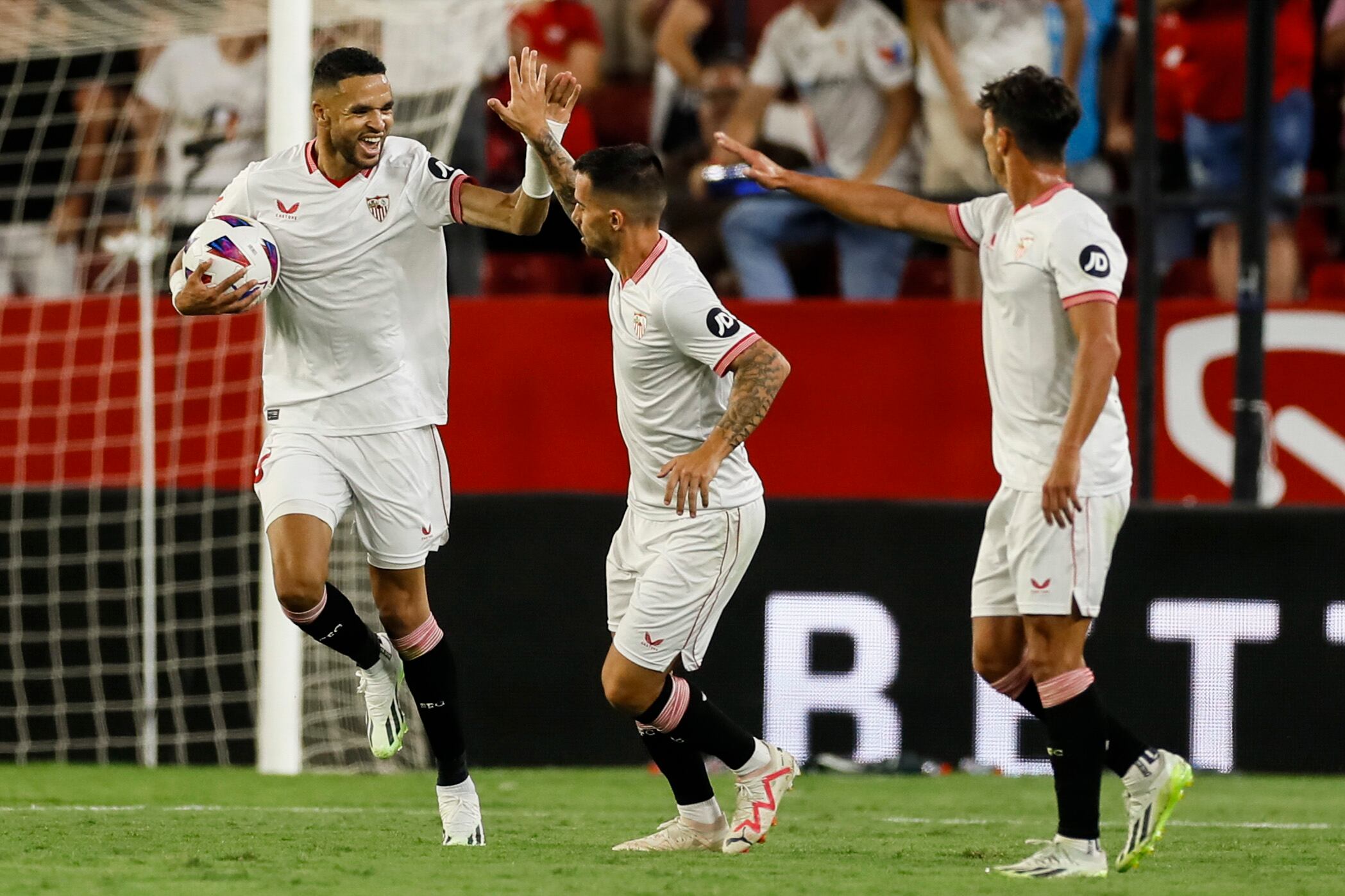 SEVILLA, 11/08/2023.- El delantero del Sevilla Youssef En-Nesiry (i) celebra con sus compañeros tras marcar ante el Valencia, durante el partido de LaLiga disputado este viernes en el estadio Sánchez Pizjuán, en Sevilla. EFE/José Manuel Vidal
