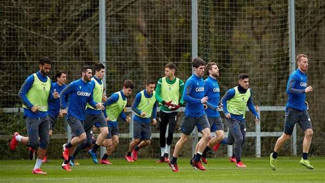 Los jugadores de la Real corren sobre el césped de Zubieta