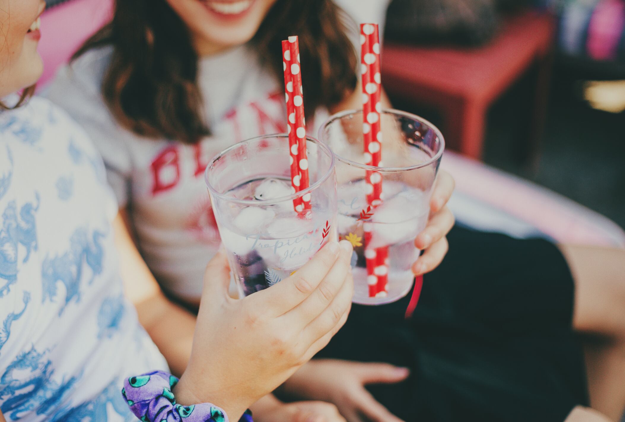 Dos adolescentes con vasos en una fiesta