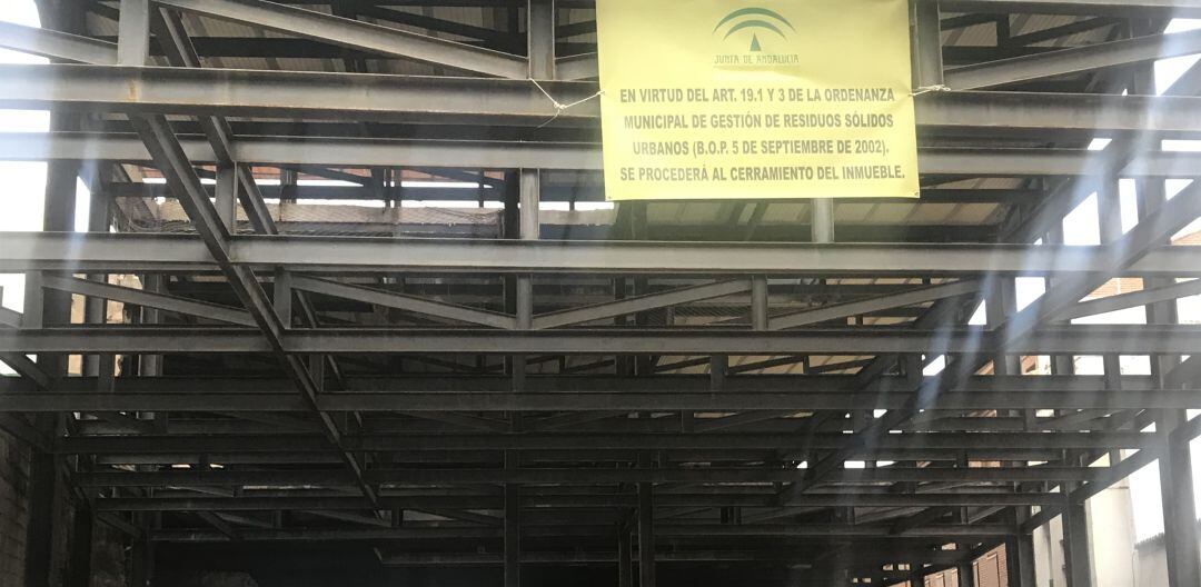 Vehículos estacionados en un solar-aparcamiento sobre el que ya cuelga el cartel que advierte de su futuro cierre.
