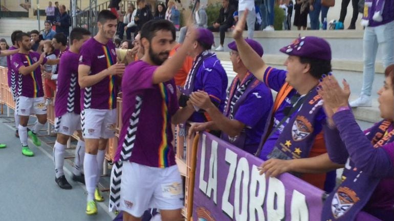 Los jugadores morados saludan a los aficionados de la Peña La Zorra Alcarreña desplazados al Villa de Yuncos.