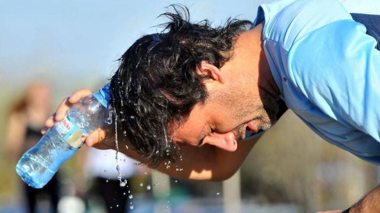 Una persona se refresca para combatir los efectos de las altas temperaturas