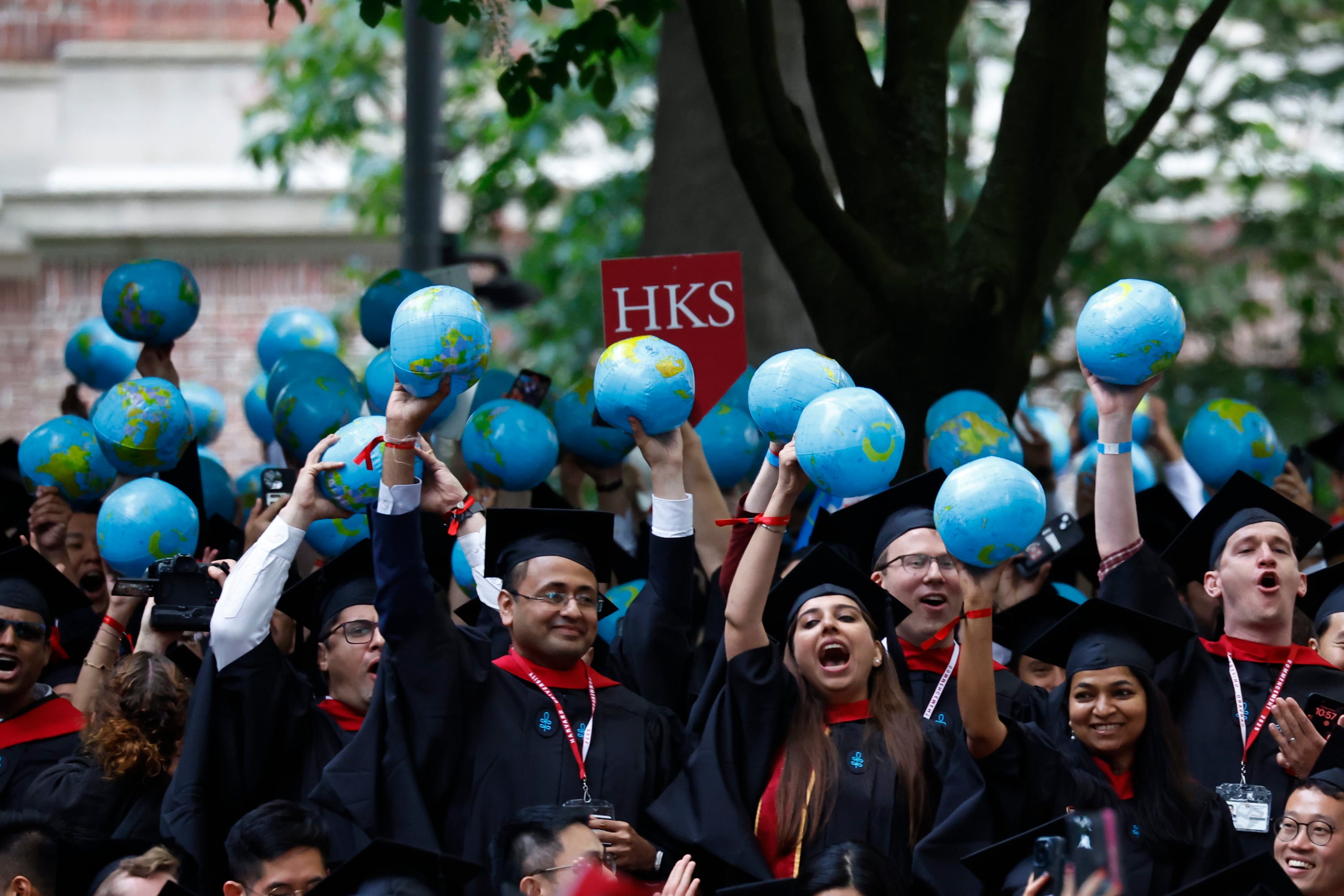 Alumnos de la Universidad de Harvard sostienen globos representando el mundo durante la ceremonia de graduación del curso de 2025. EFE/EPA/CJ GUNTHER