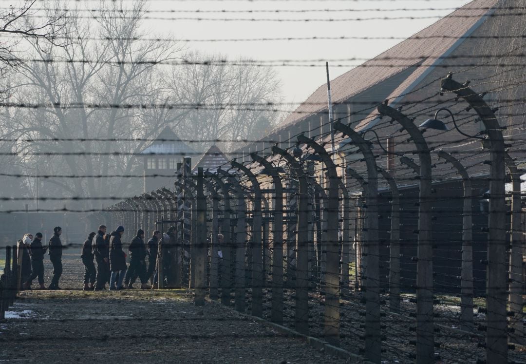 Visitantes cruzando la verja del campo de Auschwitz