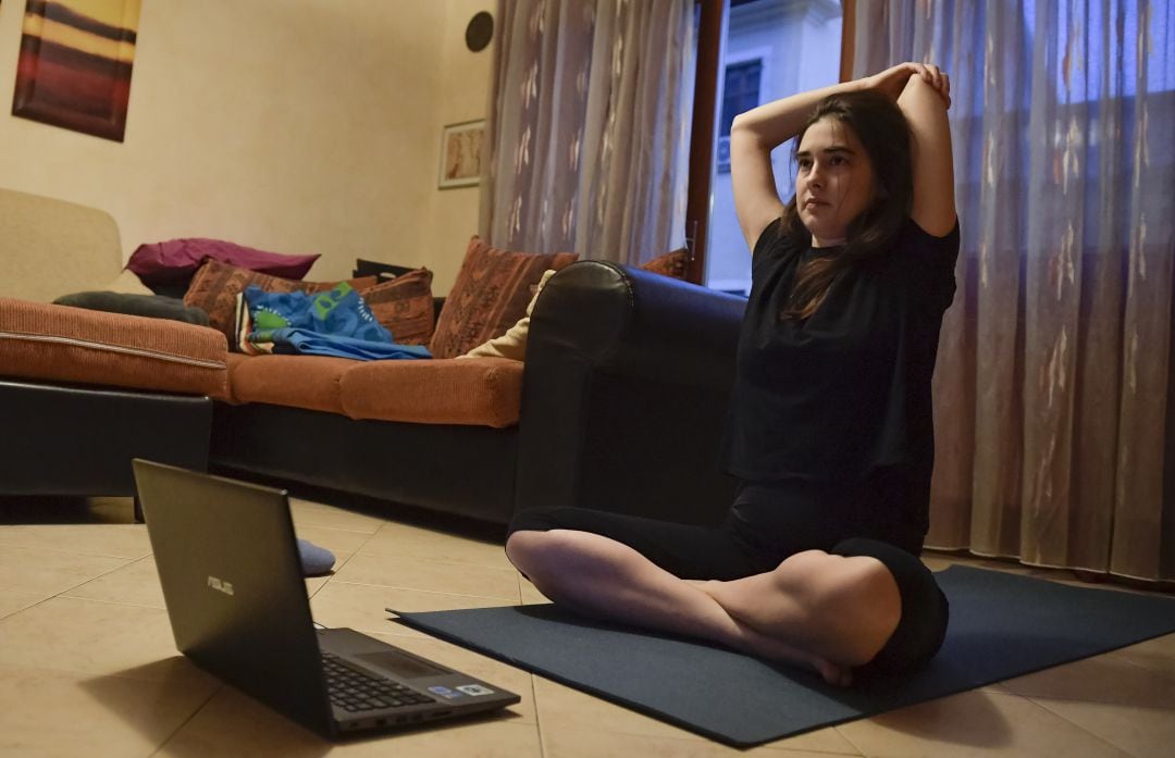 Una chica italiana sigue una clase online de yoga desde su casa debido a las restricciones impuestas en el país para evitar que se extienda el contagio por coronavirus.