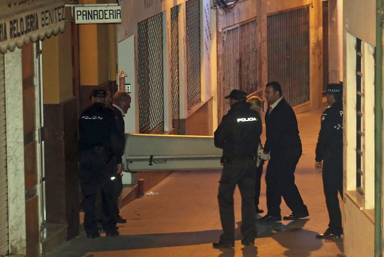 Miembros de los servicios funerarios, transportan el féretro con uno de los cadáveres de la pareja encontrada hoy en el domicilio granadino de Baza