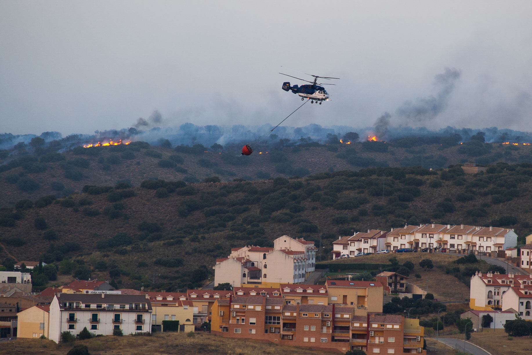 RUIDERA (CIUDAD REAL), 25/07/2022.- Efectivos del Servicio de Extinción de Incendios de Castilla-La Mancha (Infocam) luchan este lunes para evitar que el incendio forestal que se encuentra activo en el Parque Natural de Las Lagunas de Ruidera, en la provincia de Ciudad Real, pueda afectar a la urbanización &quot;Los Villares&quot;. EFE/Jesús Monroy
