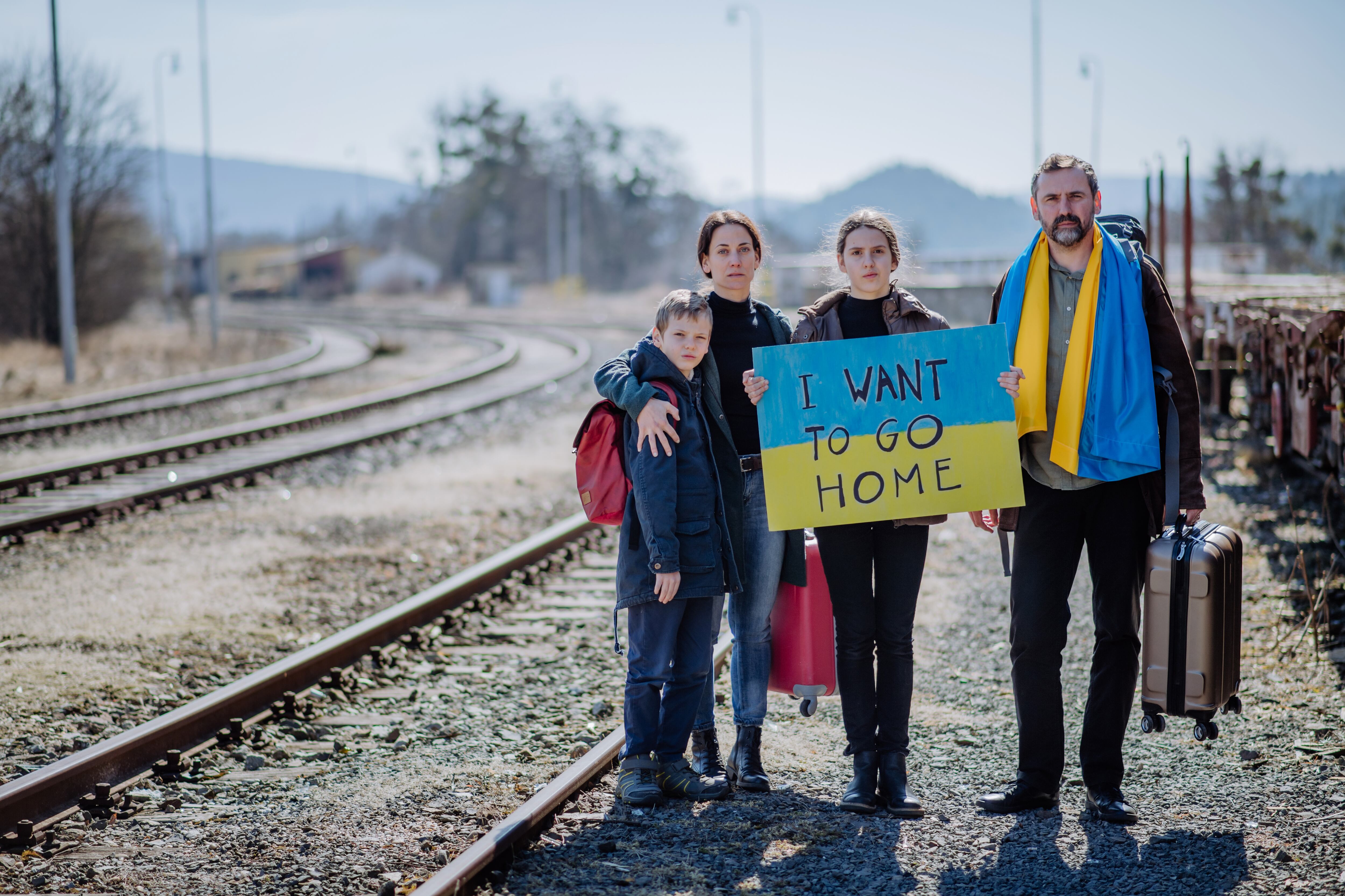 Una familia de refugiados ucranianos espera en una estación de tren