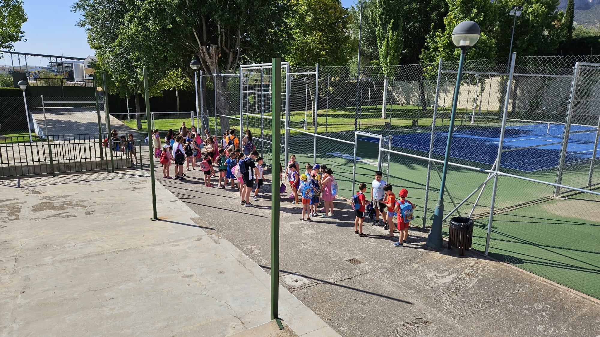 Los niños y niñas se incorporan a la zona de sombras-césped de la piscina