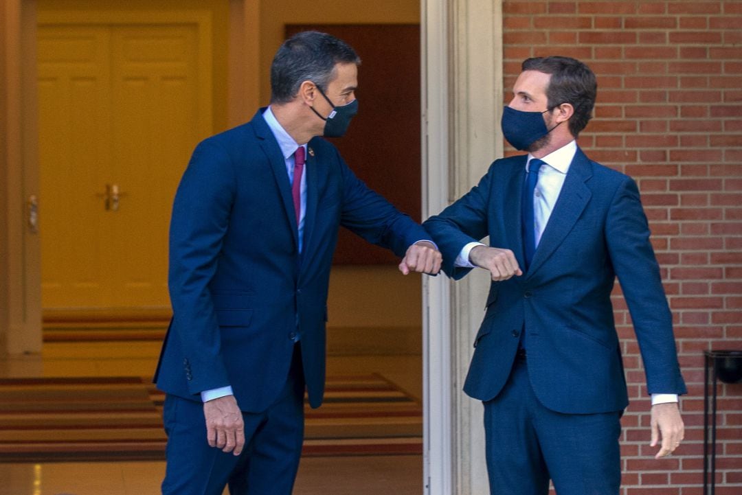 El presidente del Gobierno, Pedro Sánchez y el presidente del PP, Pablo Casado, se saludan con el codo en el Palacio de Moncloa.