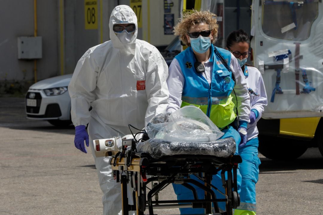 Dos sanitarios del SUMMA trasladan una camilla hacia el interior del hospital temporal de IFEMA para el posterior traslado de un paciente desde la UVI de IFEMA al Hospital Puerta de Hierro