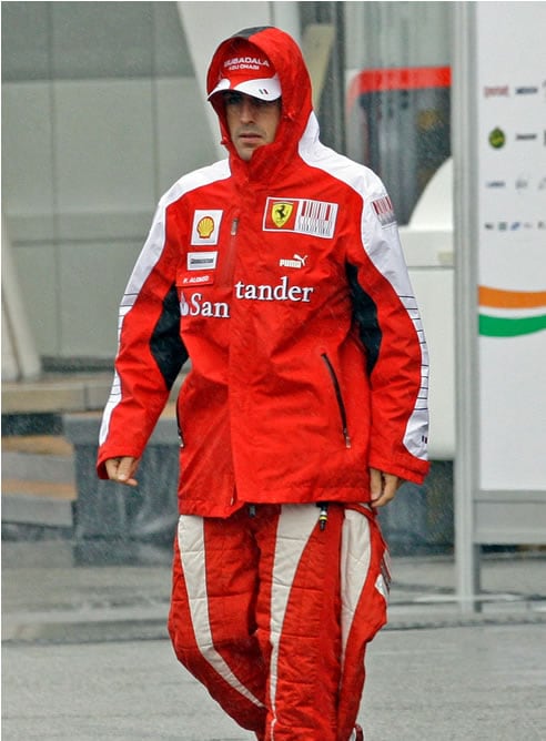 Alonso camina por el paddock durante el GP de Alemania mientras la lluvia cae