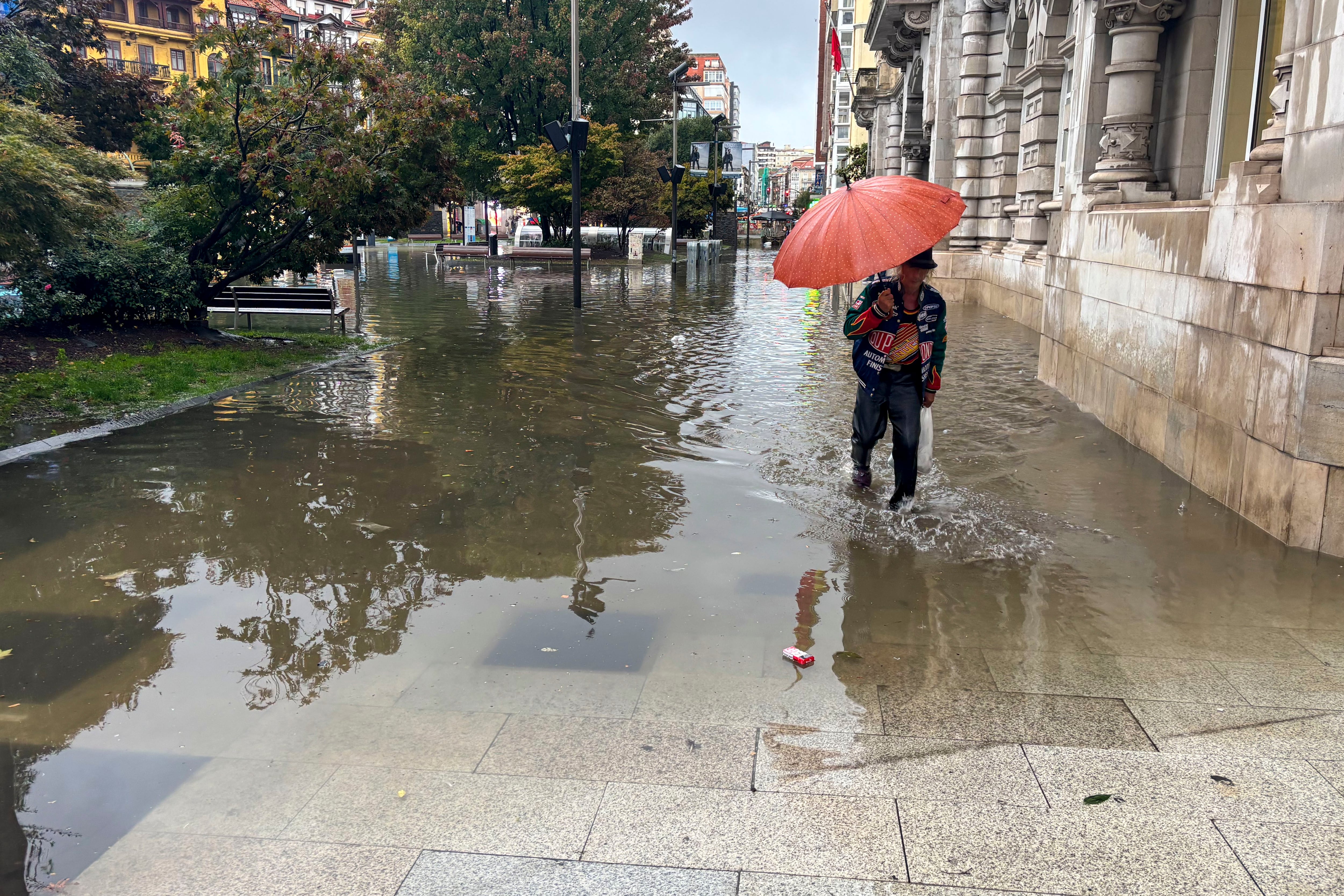 SANTANDER, 22/09/2025.- Una persona intenta atravesar una calle inundada de Santander durante la tormenta registrada este lunes. Santander registra la mayor cantidad de precipitación acumulada en España hasta las 17.30 horas de este lunes, con 84,2 litros por metro cuadrado. EFE/Kike Serrano Mirones
