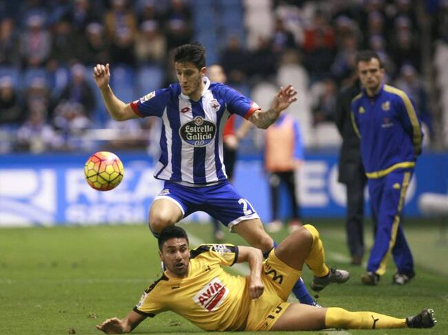 El delantero del Deportivo Luis Alberto (arriba) supera la entrada del argentino Dos Santos, del Eibar, durante el partido de Liga en Primera División que disputaron en el estadio de Riazor, en A Coruña