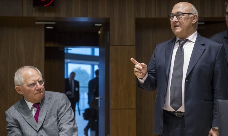 El ministro germano de Finanzas, Wolfgang Schäuble, conversa con su homólogo galo, Michel Sapin, antes del comienzo de la reunión del consejo de ministros de Economía y Finanzas de la Unión Europea (UE) en la sede de la UE en Luxemburgo.