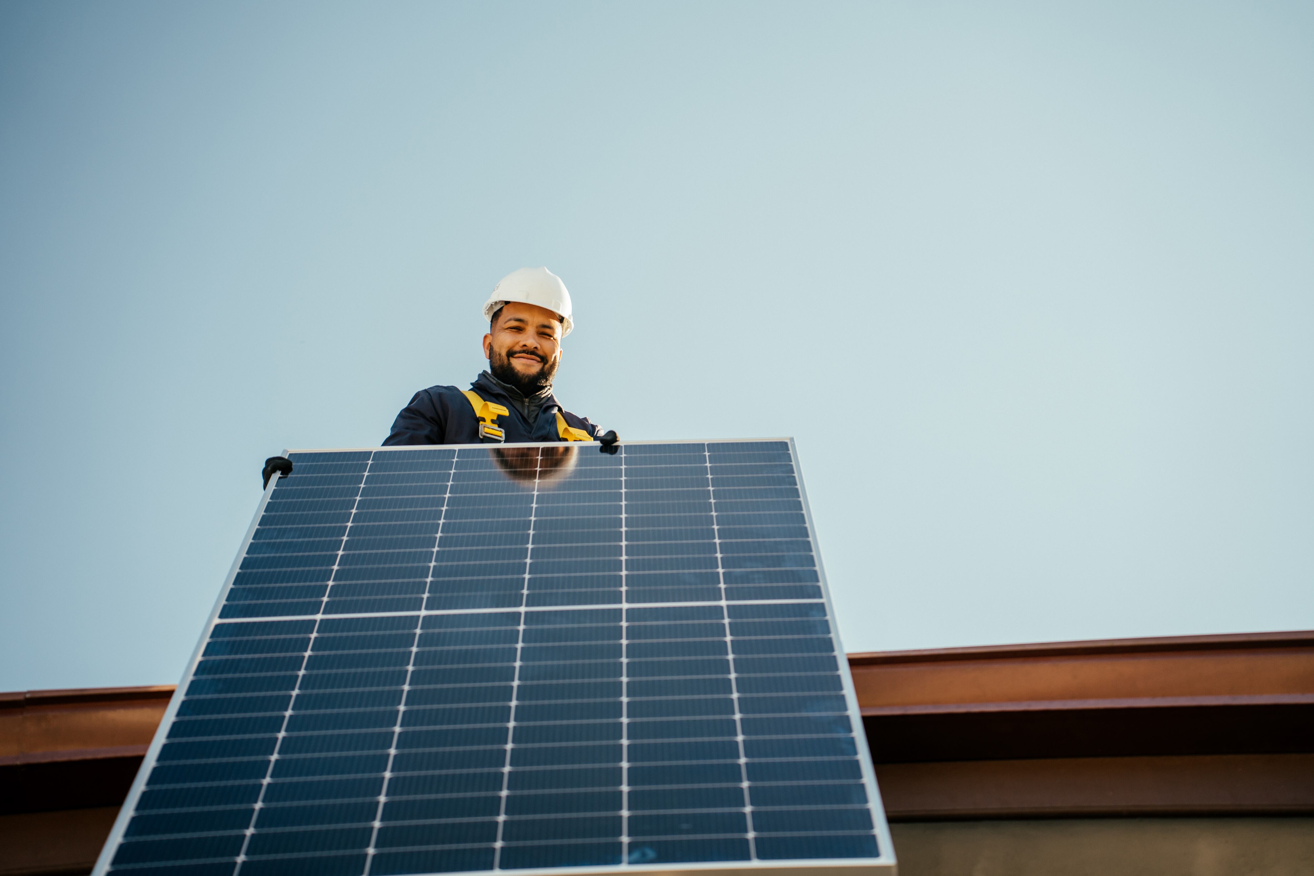 Worker holding solar panel to start installation