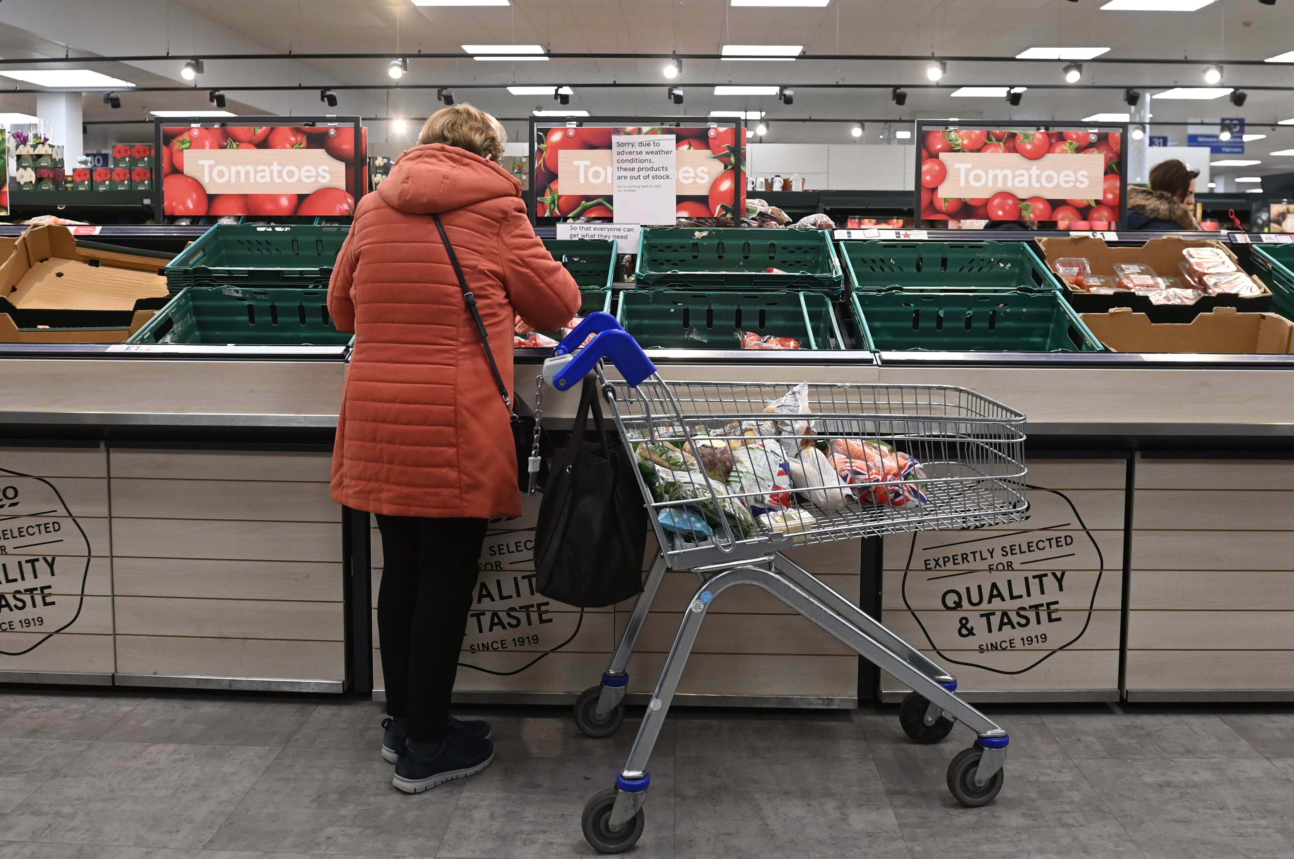 Una mujer observa unos tomates en la zona de productos frescos de un supermercado