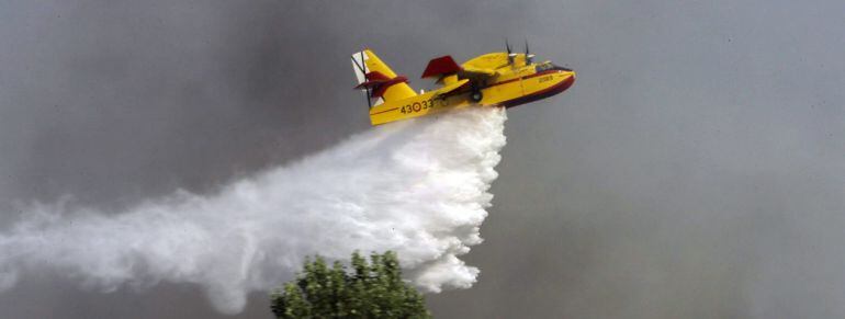 GRA459. HUMANES (GUADALAJARA), 07/07/2015.- Un hidroavión trabaja en las labores de extinción del incendio forestal declarado hoy en Humanes (Guadalajara), y que ha obligado a desalojar Fuencemillán y Montarrón. El fuego se ha producido en una zona de cultivo, matorral y monte bajo y ha provocado además el corte de la carreta CM-101 y la interrupción del tráfico en una línea de ferrocarril. EFE/Pepe Zamora