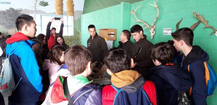 Los escolares atienden a las explicaciones de los alumnos del centro de capacitación forestal de Vadillo