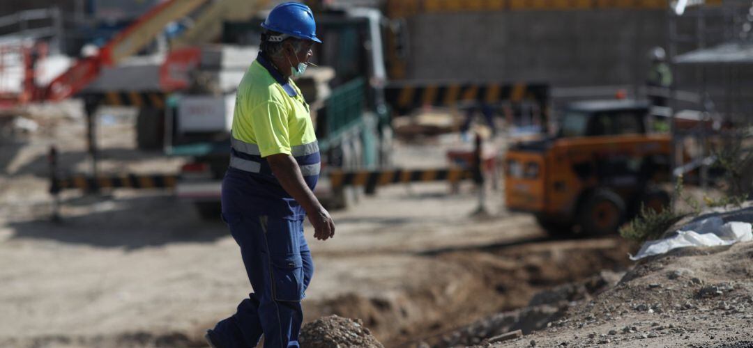 Un obrero trabaja con maquinaria de construcción.