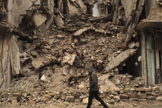 Un hombre camina junto a un edificio derruido en el barrio de al-Mashad en la zona controlada por los rebeldes en Alepo