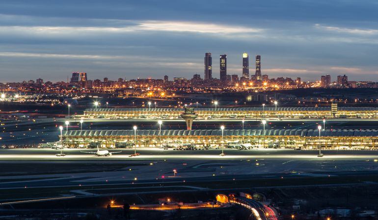 El aeropuerto de Barajas y, al fondo, la ciudad de Madrid, en una imagen tomada al atardecer.