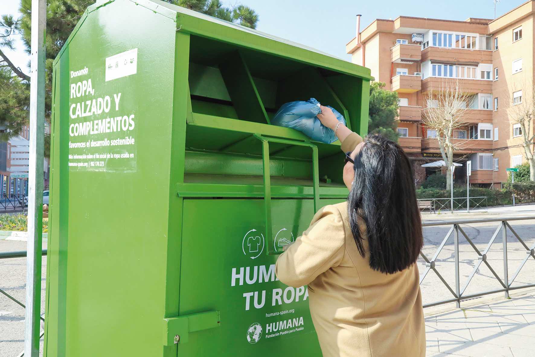 Vecina depositando una prenda de ropa en un contenedor de la ONG Humana en Alcobendas