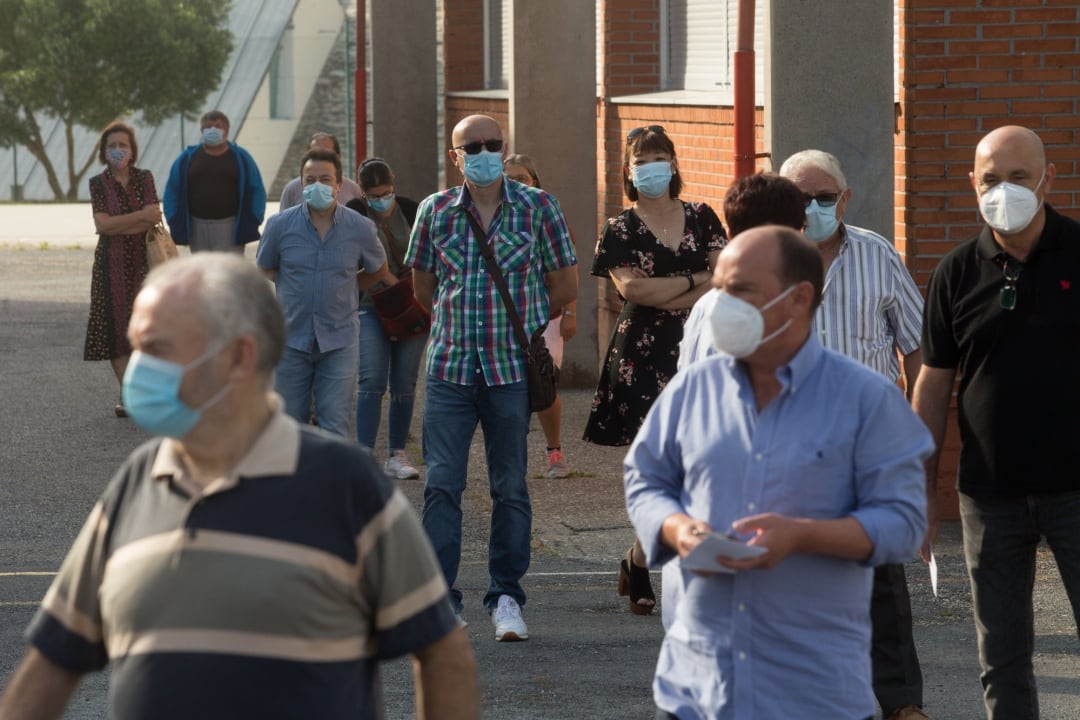 Varias personas hacen cola para votar en las elecciones autonómicas de Galicia en el Pabellón Os Castros de la población de Burela, en la comarca de A Mariña, Lugo, Galicia (España), a 12 de julio de 2020.