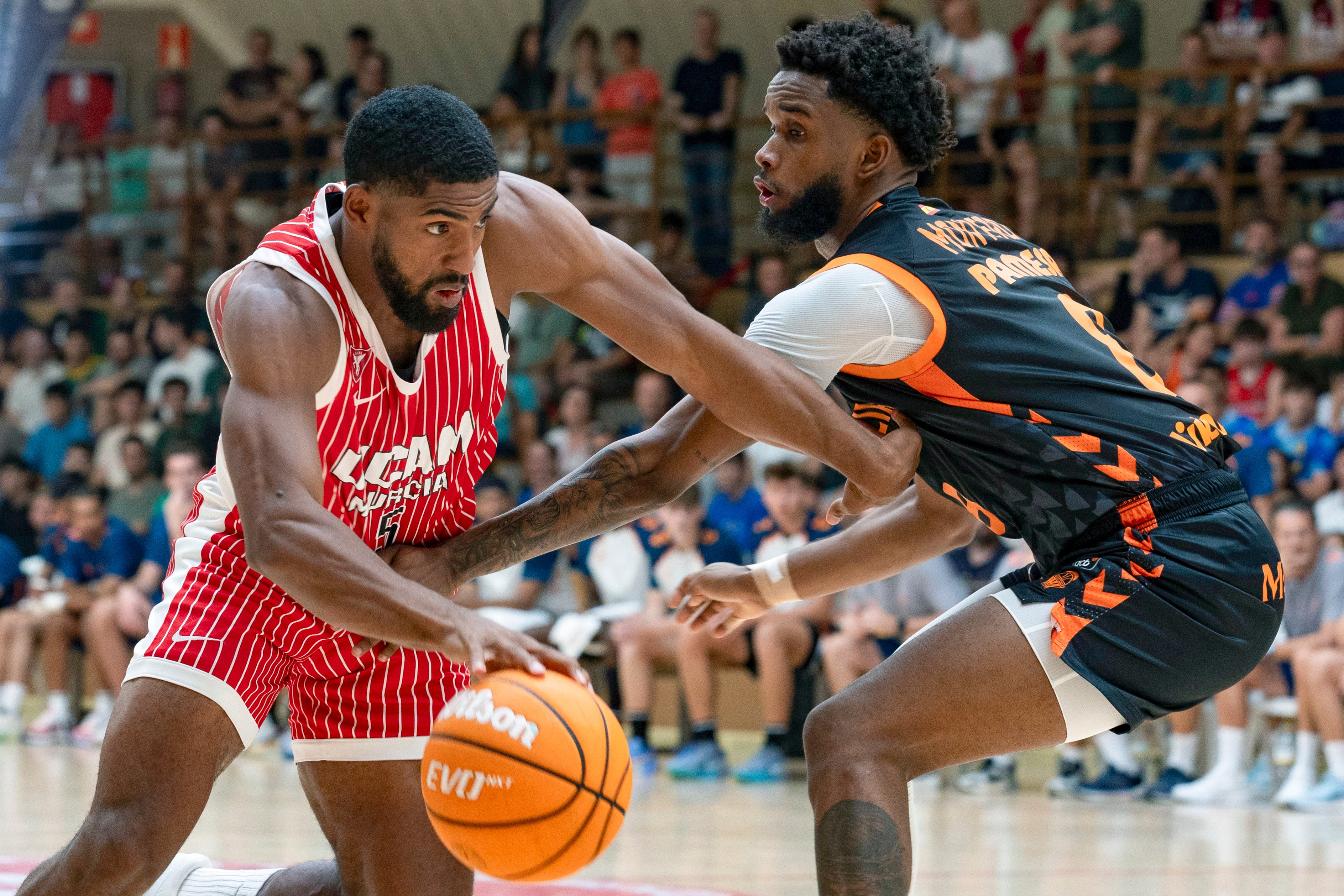 YECLA (MURCIA), 07/09/2025.- El base del UCAM Murcia David de Julius (i) bota el balón ante el del base del Valencia Basket Jean Montero (d) durante el partido del Torneo Costa Cálida celebrado este domingo en el pabellón José Ortega Chumilla de Yecla. EFE/Marcial Guillén