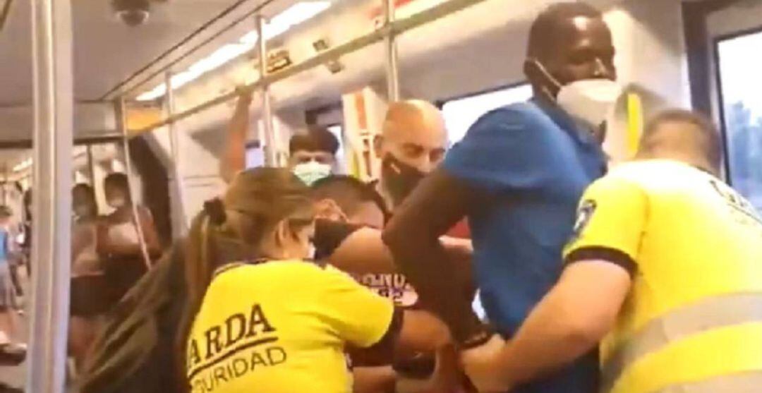 Fotograma del vídeo compartido en redes donde se ve a los guardias de seguridad y a ciudadanos retener y esposar al joven negro por no llevar correctamente la mascarilla en el metro de València