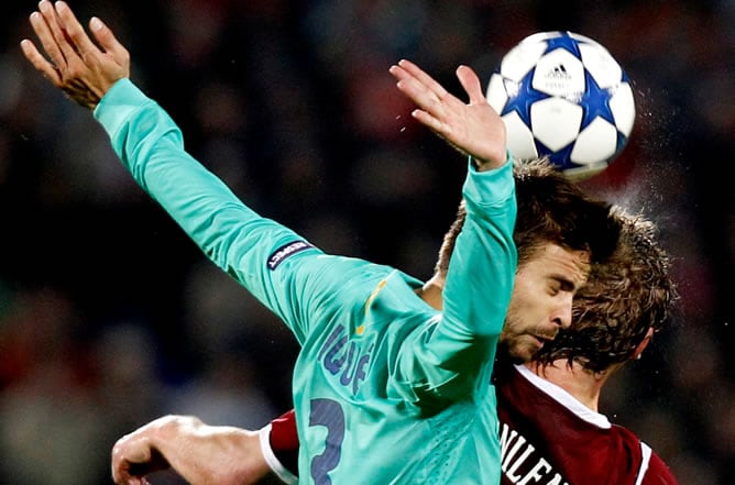 Gerard Piqué trata de cabecear un balón junto al jugador del Rubin Kazan Sergey Kornilenko