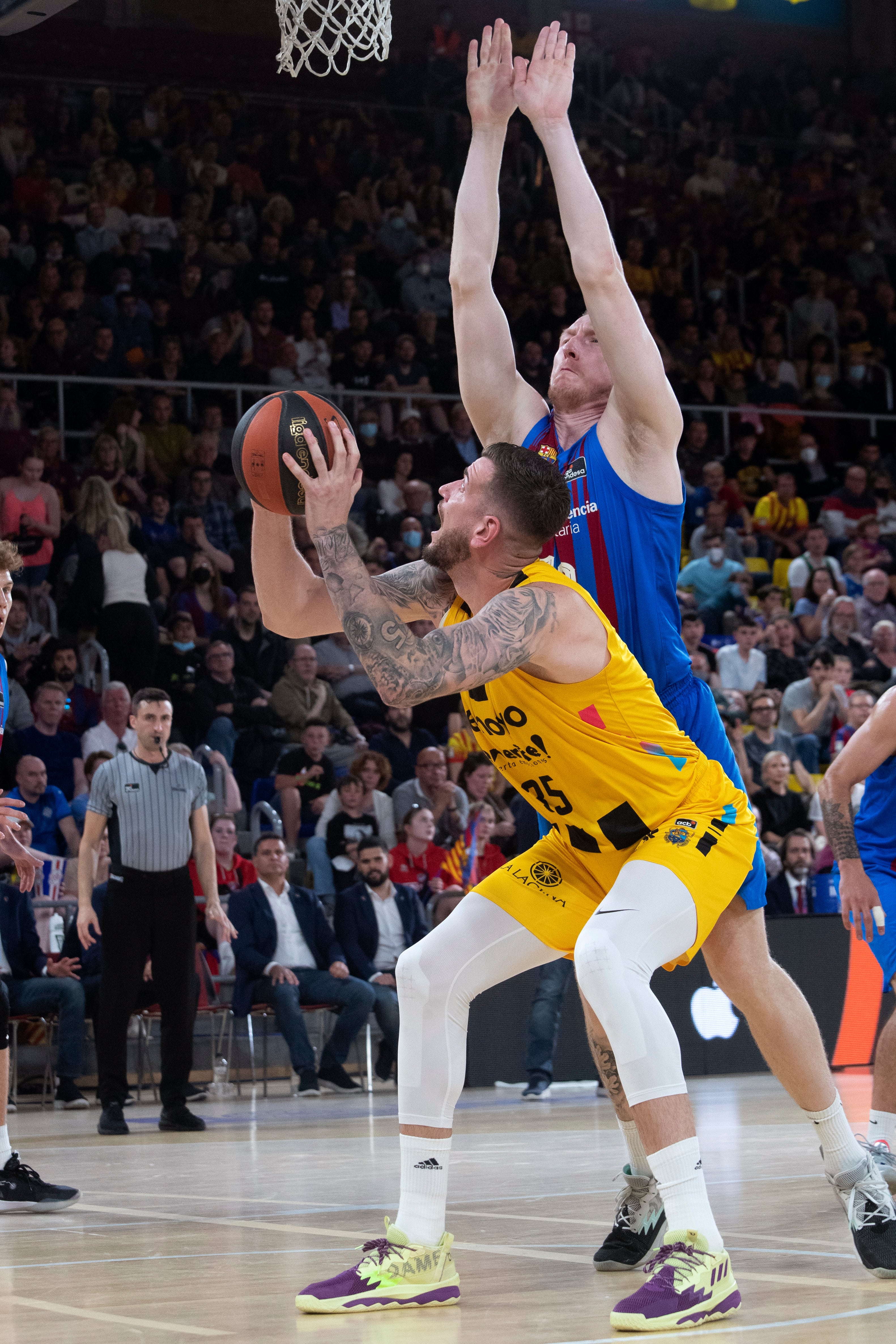 BARCELONA, 24/04/2022.- El pivot de Lenovo Tenerife, Fran Guerra (i), intenta encestar ante la defensa del ala pivot letón del Barça, Rolands Smits, durante el encuentro de la fase regular de la ACB disputado hoy Domingo en el Palau Blaugrana. EFE/Marta Pérez.