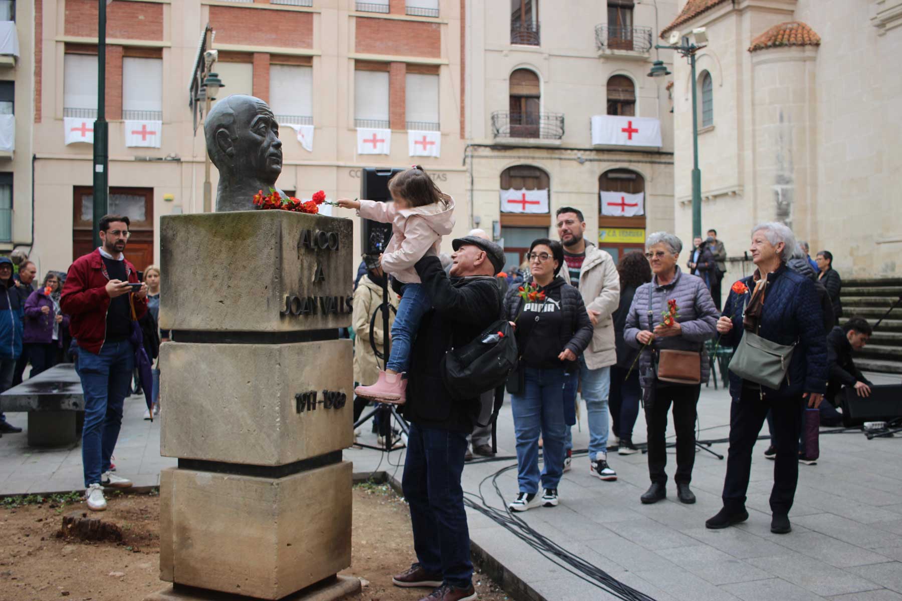 Manel Rodríguez Castelló ajuda a una jove participant en l'ofrena de flors al monument de Joan Valls en la part final de l'acte d'homenatge