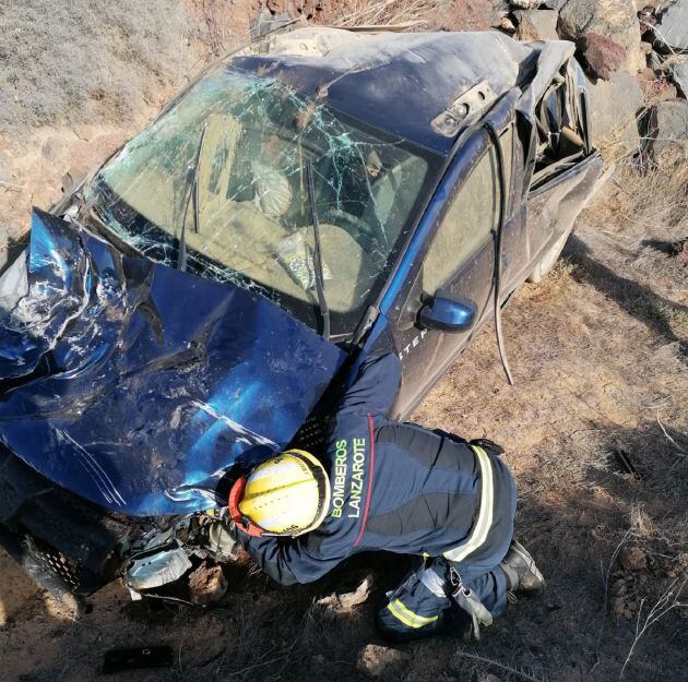 Un bombero inspecciona el vehículo accidentado cerca de Yaiza.