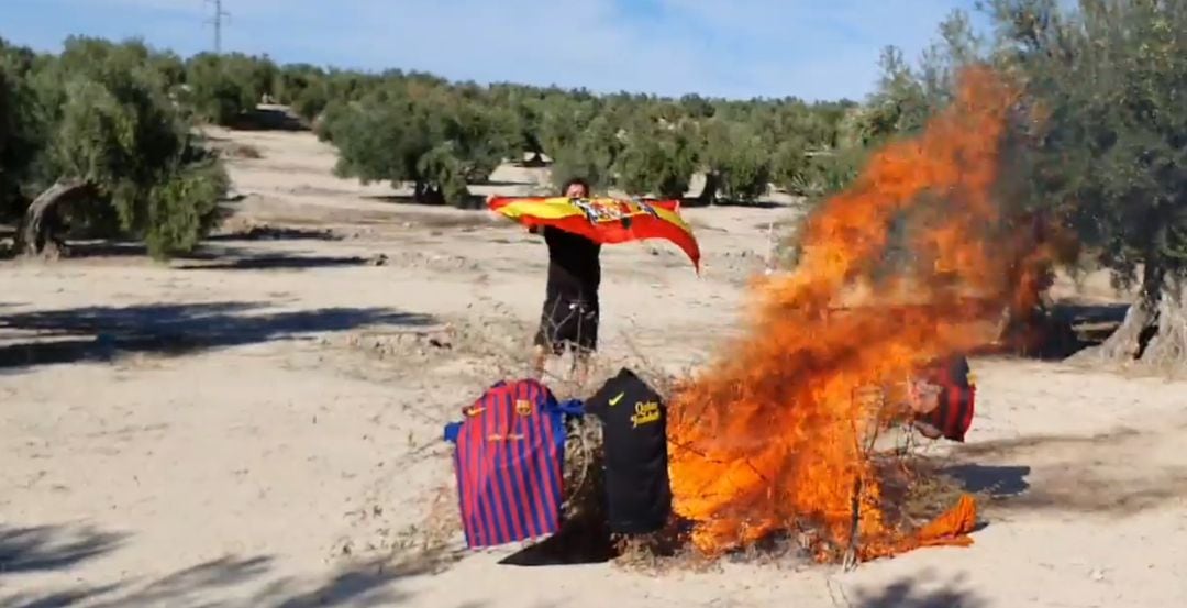 Fuego en el que arden las camisetas del FC Barcelona mientras que Joaquín Ibarra posa con la bandera de España franquista.